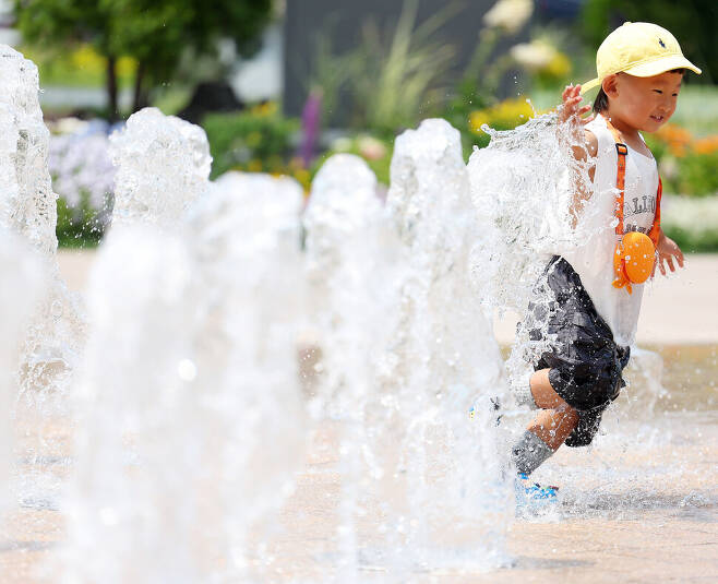 서울 지역 낮 최고기온이 올 들어 가장 높은 30.7도까지 치솟은 23일 서울광장 분수대에서 한 어린이가 물놀이를 즐기고 있다. 연합뉴스