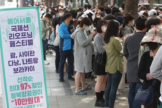 지난 3월 서울 종로구 커피빈 광화문점 앞에서 시민들이 '에어서울 국제선 리오프닝 기념 할인 이벤트' 항공권 구매를 위해 길게 줄을 서고 있다. 에어서울은 국제선 운항 재개를 기념해 홈페이지 회원을 대상으로 괌, 사이판, 나트랑, 다낭, 보라카이 동남아 노선의 왕복 항공권을 최대 97% 할인된 가격에 선착순으로 판매했다. 뉴스1