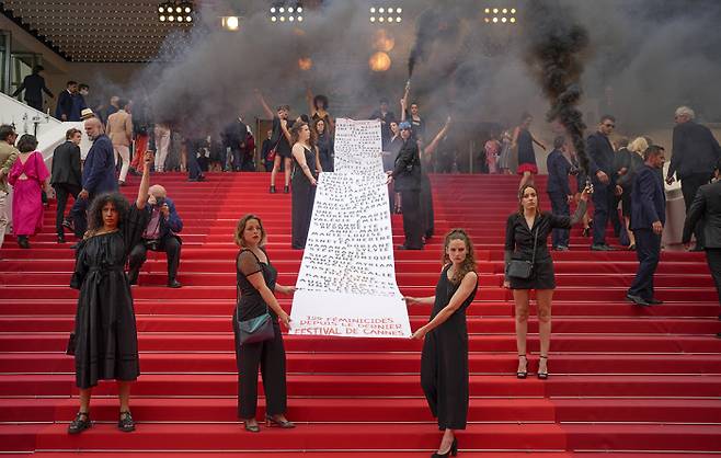 프랑스 페미니스트 단체 ‘Les Colleuses’ 일원들이 22일(현지시간) 열린 제75회 칸 국제영화제 레드카펫에서 ‘페미사이드(여성살해)’ 피해자들을 추모하는 퍼포먼스를 선보였다. AP연합뉴스
