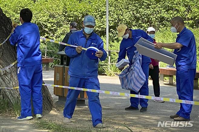 [베이징=AP/뉴시스] 17일 중국 베이징에서 근로자들이 수로를 접한 녹지 공간 일부를 폐쇄하는 '출입금지' 테이프를 붙이고 있다. 2022.05.17