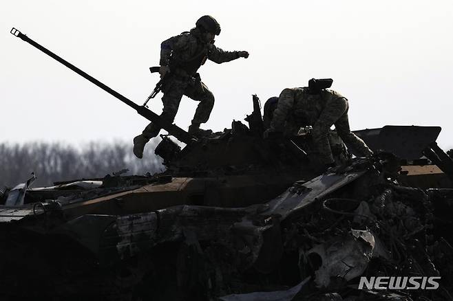 [부차=AP/뉴시스] 지난달 7일(현지시간) 우크라이나 키이우 외곽 부차에서 우크라이나 군인들이 파괴된 러시아군 전투 차량을 살피고 있다. 2022.05.24.