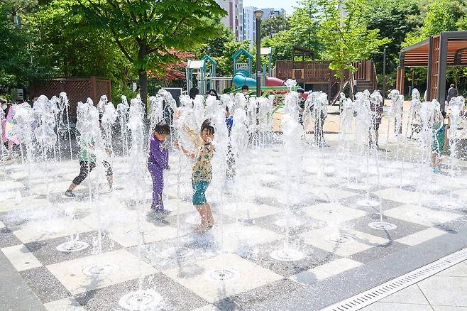 24일 서울 양천구 하늘마루 어린이공원 분수대에서 어린이들이 신나게 물놀이를 하고 있다. 뉴스1