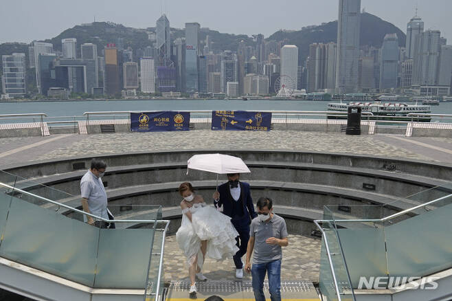 [홍콩=AP/뉴시스] 홍콩에서 21일 결혼을 앞둔 커플이 코로나19 예방을 위해 마스크를 착용한 채 웨딩촬영을 하고 있다. 2022.05.21