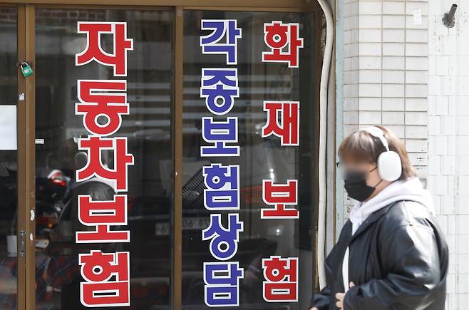 지난 3월 한 20대 청년이 서울의 한 보험영업소 앞을 지나가고 있는 모습./뉴시스