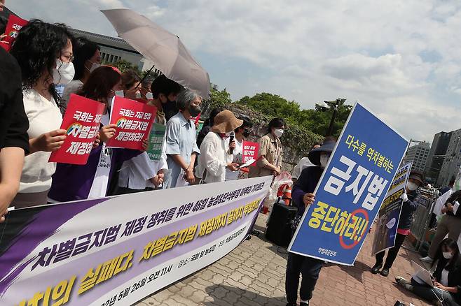 차별금지법 제정을 요구하는 단식농성 46일째인 26일 서울 여의도 국회의사당 앞에서 열린 농성&단식투쟁 마무리 기자회견에서 차별금지법제정을 반대하는 시민들이 대형팻말을 들고 지나가고 있다. 백소아 기자