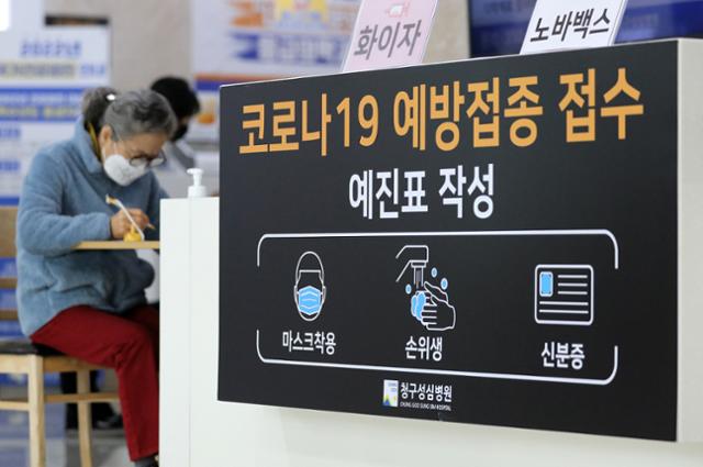 4월 14일 오후 서울 은평구 청구성심병원에서 한 시민이 코로나19 백신 4차 접종에 앞서 서류를 작성하고 있다. 뉴스1