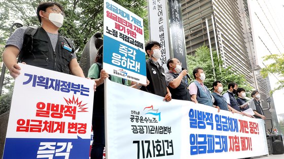 민주노총 공공운수노조 조합원들이 지난해 6월 25일 오후 서울 경제사회노동위원회(경사노위) 앞에서 기자회견을 열고 공공기관의 일방적 임금체계 개편 중단과 임금피크제 지침 폐기를 촉구하고 있다. 뉴스1