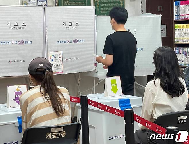 제8회 전국동시지방선거 사전투표 첫날인 27일 오전 부산 부산진구 개금제1동 주민센터에 마련된 사전투표소에서 유권자가 투표용지를 들고 기표소로 들어가고 있다.2022.5.27 © News1 이유진 기자