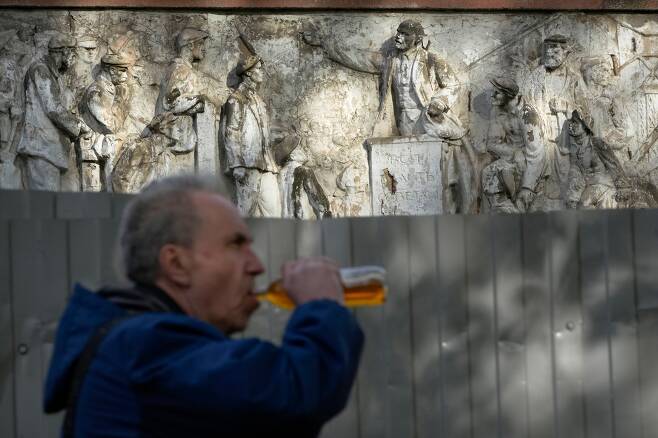 25일(현지 시각) 러시아 상트페테르부르크에서 한 남성이 옛 소련 시절을 묘사한 조각 작품 앞을 지나가고 있다. /AP 연합뉴스