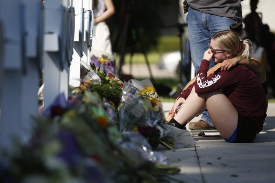 26일 미국 텍사스주 우밸디에서 발생한 초등학교 총기난사 사건의 희생자를 추모하는 자리에서 한 여성이 슬픔에 잠겨 있다.[AP=연합뉴스]