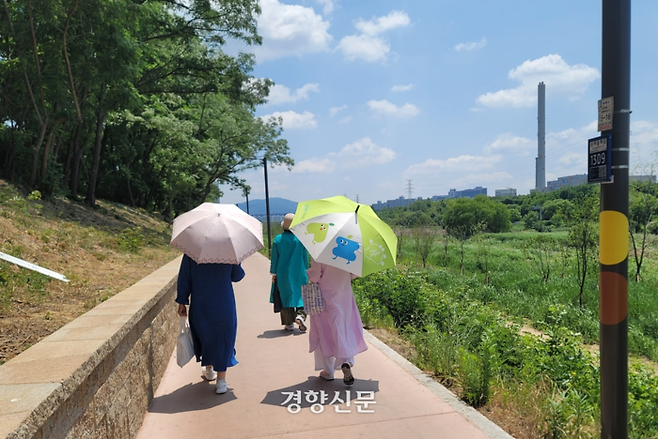27일 서울 송파구 탄현길에서 시민들이 구청에서 빌려준 양산을 들고 걸어가고 있다. 김현수 기자