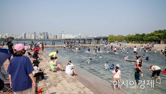 서울 한 낮 기온이 27도까지 오르며 초여름 더위가 이어지고 있는 22일 서울 여의도 한강공원 물빛광장을 찾은 시민들이 물놀이를 하며 더위를 식히고 있다./강진형 기자aymsdream@