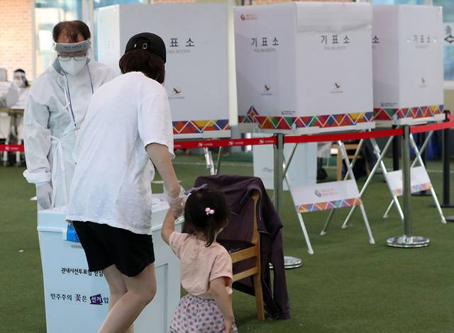 ▲ 제8회 전국동시지방선거 사전투표 둘째 날인 28일 오후 강원 춘천시 신사우동 사전투표소가 마련된 춘천북부노인복지관에서 신종 코로나바이러스 감염증(코로나19) 확진 선거인이 어린 딸과 함께 투표하고 있다. 연합뉴스