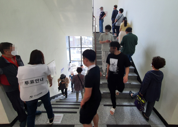 사전투표 이틀째인 28일 한 투표소 계단에서 순서를 기다리고 있는 시민 모습.  연합뉴스