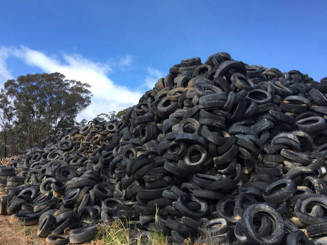 야외에 쌓여 있는 폐타이어들. 최근 호주 과학자들이 폐타이어를 잘게 분쇄해 얻은 고무를 아스팔트에 섞어 자외선에 의한 도로 파손을 완화시키는 기술을 개발했다. 호주 타이어 스튜어드십 제공