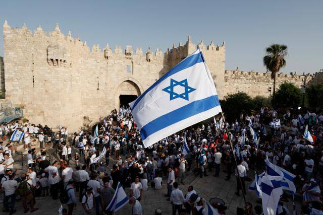 29일 '예루살렘을 날'을 맞아 국기 행진을 벌이는 이스라엘 극우파 시위대가 예루살렘 구시가지에 있는 다마스쿠스 게이트 앞에서 이스라엘 국기를 흔들고 있다. 이날 팔레스타인 주거지에 진입한 시위대와 팔레스타인 주민들 간 무력 충돌이 빚어졌다. 예루살렘=EPA 연합뉴스