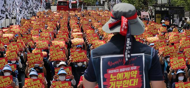 민주노총 서비스연맹 전국택배노동조합원들이 13일 오전 서울 세종대로 광화문사거리 일대에서 열린 '임금삭감, 쉬운 해고 노예계약 저지' 우체국 택배 노동자 총력 결의대회에서 노예계약서를 거부하며 손 피켓을 들고 있다. /뉴스1