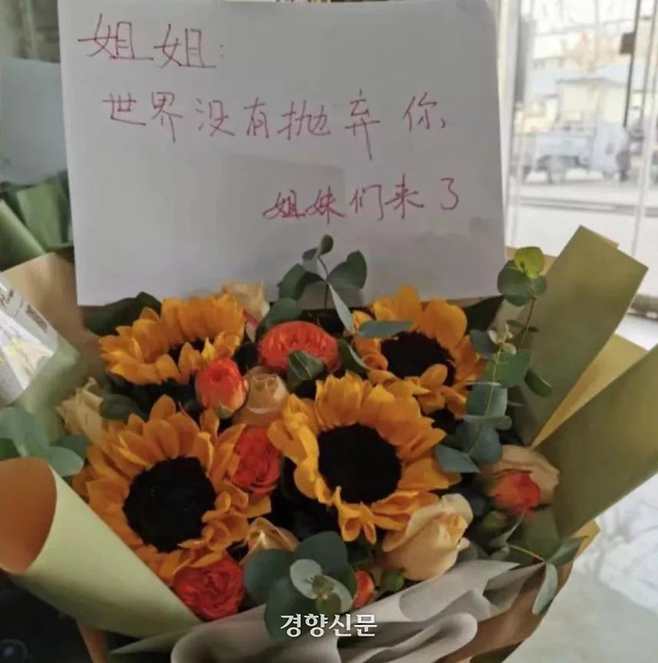 베이징의 한 공원에 펑현의 쇠사슬에 묶인 여성에 대한 연대의 뜻을 담은 메모와 꽃다발이 놓여 있다. “세상은 아직 언니를 버리지 않았어. 동생들이 구하러 왔어”라고 적혀 있다. /독자 제공