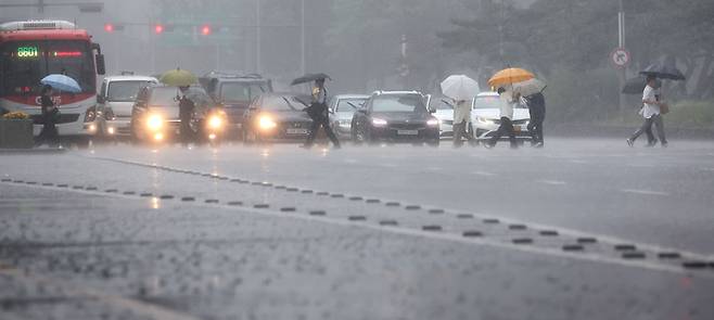 서울·인천·경기 지역에 호우주의보가 내려진 23일 오후 서울 여의대로에서 시민들이 우산을 쓴 채 걸어가고 있다. 연합뉴스.