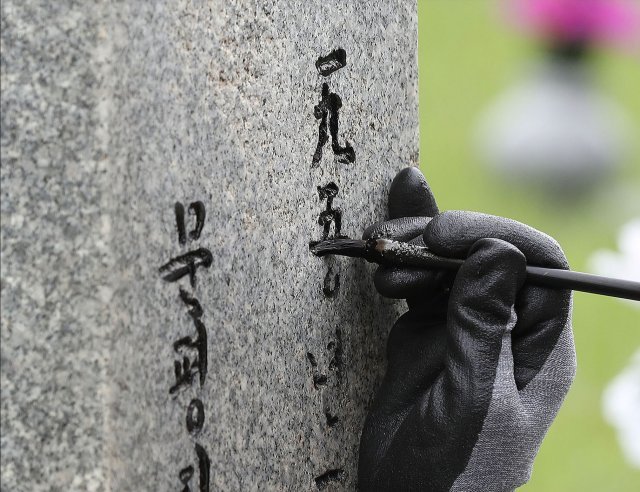 6.25 전쟁 발발 72주년을 하루 앞둔 24일 서울 동작구 국립서울현충원 6.25 전사자 묘역에서 자원봉사자들이 묘비 덧칠 작업을 하고있다.