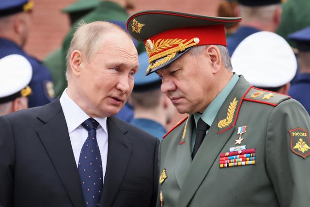 블라디미르 푸틴(왼쪽) 러시아 대통령이 22일 나치 독일의 소련 침공 81주년을 맞아 모스크바 '무명용사의 묘' 헌화 행사에 참석해 세르게이 쇼이구 국방장관과 대화하고 있다. 모스크바=AP 연합뉴스