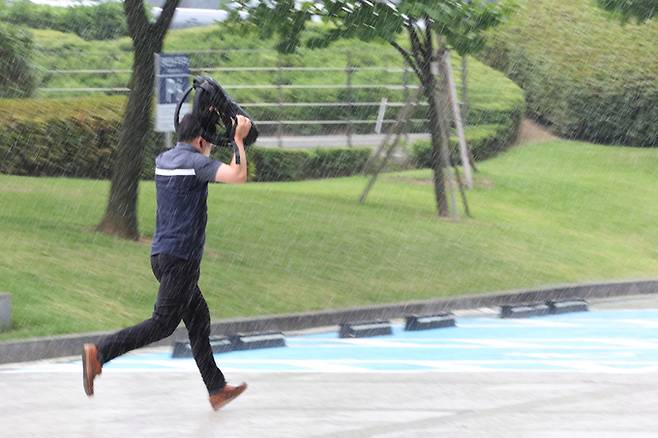 소나기가 내린 지난 23일 오전 서울 서초동에서 출근길에 오른 한 시민이 가방으로 비를 막으며 뛰어가고 있다. 연합뉴스