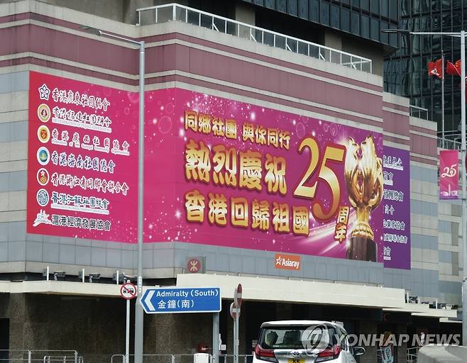 (신화=연합뉴스) 다음 달 1일 주권 반환 25주년을 맞는 홍콩의 한 건물에 지난 22일 이를 기념하는 현수막이 내걸린 모습.2022.6.24.