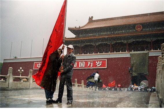 <1989년 5월 23일 베이징 자금성 톈안먼 성루에 걸린 마오쩌둥의 초상화가 카키색 천에 싸여 있고, 그 아래 일군의 시위대가 깃발을 들고 구호를 외치고 있다. 당시 시위 군중은 마오쩌둥의 초상화에 파랑, 빨강, 노랑 페인트를 뿌리는 강력한 퍼포먼스까지 연출했다. 사진/AFP>