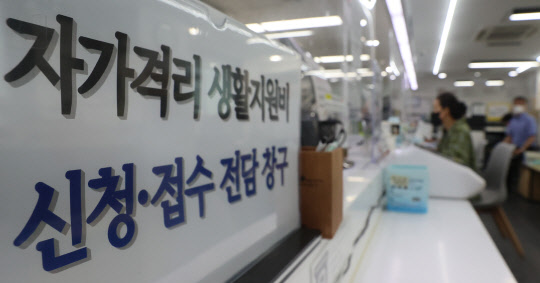24일 오후 서울 시내 한 주민센터에 자가격리 생활지원비 신청 창구 안내문이 붙어있다.  연합뉴스