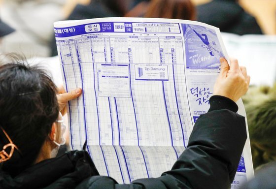지난해 12월 17일 서울 성동구청에서 열린 2022학년도 대입 정시 설명회에서 한 학부모가 배치표를 보고 있다. [뉴스1]