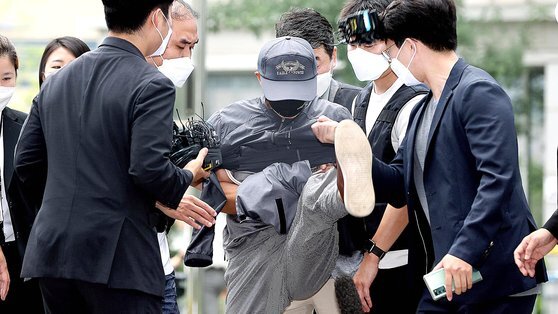 강윤성이 지난해 8월 31일 서울동부지법에서 열리는 영장실질심사에 출석하며 취재진의 마이크를 발로 차고 있다. 연합뉴스
