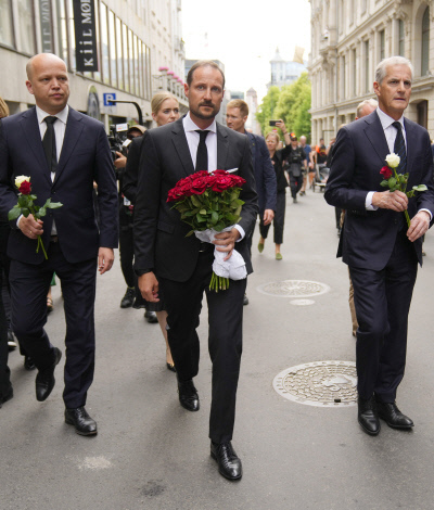 노르웨이의 하콘 왕세자(가운데)와 요나스 가르 스퇴르 총리(오른쪽)가 오슬로에서 벌어진 총기 난사 사건의 희생자들을 추모하기 위해 25일(현지시간) 사건 현장을 방문하고 있다. 오슬로 | AP연합뉴스