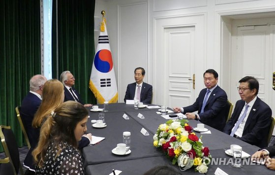 Prime Minister Han Duck-soo and Korean Chamber of Commerce and Industry Chairman Chey Tae-won have an interview with Robert Clark, chairman of the 2027 Minnesota Recognition Expo Bidding Committee, at the Intercontinental Hotel in Paris on Monday. [YONHAP]