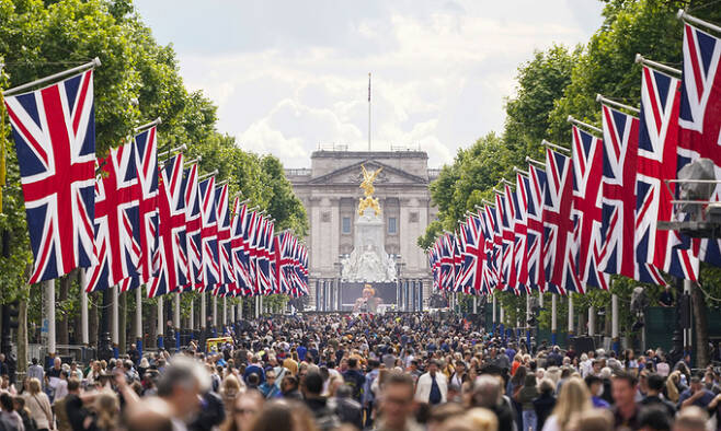 엘리자베스 2세 영국 여왕 즉위 70주년을 축하하는 플래티넘 주빌리(Platinum Jubilee) 축제를 하루 앞둔 지난 1일(현지시간) 영국 국기 유니언잭이 걸린 런던 버킹엄궁 앞 거리에 사람 물결이 가득하다. 런던=AP연합뉴스