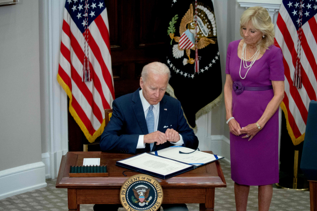 조 바이든 미국 대통령이 25일(현지 시간) 미국 백악관 루스벨트룸에서 영부인 질 바이든 여사가 지켜보는 가운데 총기 규제 법안에 서명하고 있다. 로이터연합뉴스