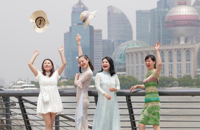 중국 정부의 상하이 봉쇄가 해제된 1일 상하이 명소 동방명주가 보이는 와이탄에서 시민들이 모자를 던지며 기뻐하고 있다. 상하이=EPA 연합뉴스
