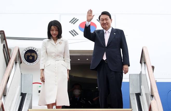 South Korean President Yoon Suk-yeol (right), alongside first lady Kim Keon-hee, waves at Seoul Air Base in Seongnam, Gyeonggi Province, on Monday, ahead of his five-day trip to Spain for the NATO summit on his first overseas trip as president. (Yonhap)
