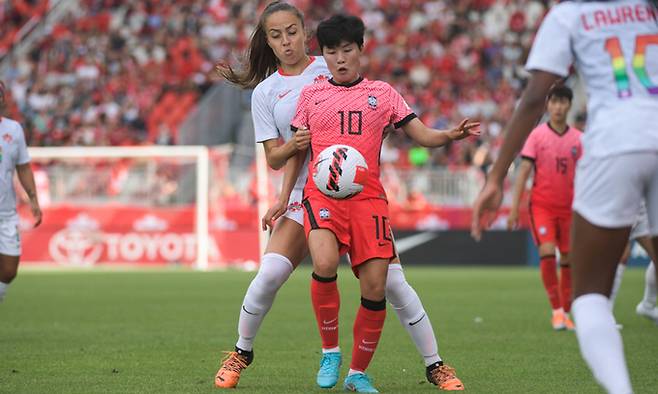 한국 여자축구대표팀 지소연(앞)이 27일 캐나다 토론토 BMO필드에서 캐나다와 치른 평가전에서 상대 수비의 견제 속 공을 다루고 있다. 대한축구협회 제공