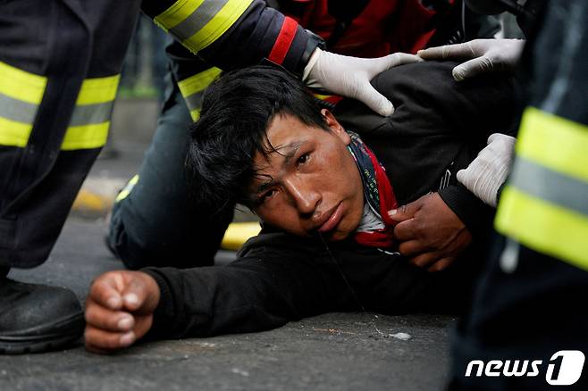 에콰도르 수도 키토에서 22일(현지시간) 한 시민이 연료, 식품 가격 급등에 항의하는 반정부 시위에 참가하던 중 부상해 치료를 받고 있다. © 로이터=뉴스1 © News1 김민수 기자