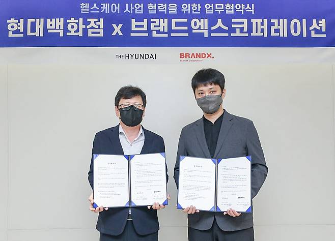 브랜드엑스코퍼레이션 박희종 부대표(오른쪽)와 현대백화점 미래사업부 박채훈 상무가 28일 현대백화점 본사에서 헬스케어 콘텐츠 강화를 위한 업무협약 체결 후 기념촬영했다.