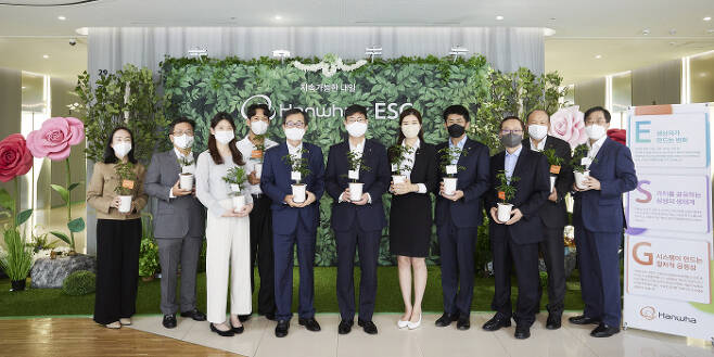 한화그룹 ESG위원회 위원들이 출범 1주년을 맞아 지난 25일 서울 중구 장교동 한화빌딩에서 ESG 반려나무를 들고 기념촬영을 하고 있다.