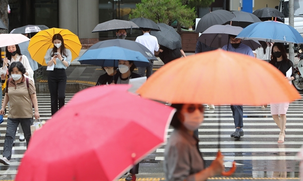 수요일에는 전국적으로 하늘이 흐리며 정체전선(장마전선)의 영향으로 누적 최대 200㎜의 비가 전국에 오겠다. 사진은 지난 27일 서울 여의도역 인근에서 우산을 쓴 시민들. /사진=뉴스1