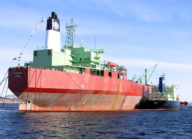 FILE PHOTO: A small cargo reloads crude oil into the storage Belokamenka, a redesigned Japanese super-tanker, built in 1980, as it stands in the Barents Sea outside the sea port of Murmansk, March 24, 2004. REUTERS/Dmitry Zhdannikov/File Photo