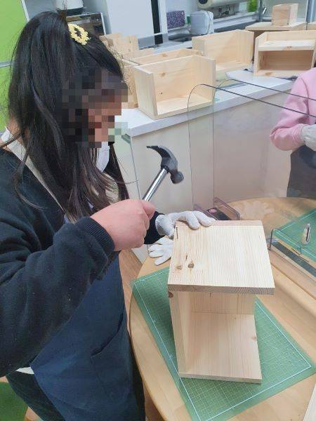 목재체험 수업시간에 학생이 망치를 들고 나무판에 못을 박고 있다.(사진=서울목원초등학교)