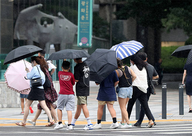 소강상태를 보이던 장맛비가 내린 29일 서울 중구 세종대로 사거리에서 우산을 쓴 시민이 발걸음을 재촉하고 있다. 뉴시스