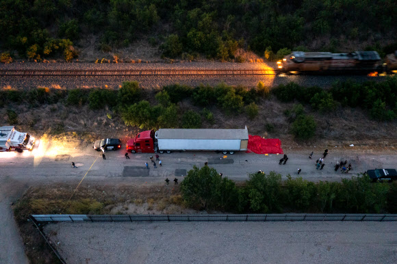 미국 텍사스주 사법당국 조사요원들이 27일(현지시간) 불법 이민을 희망하다 51명 이상이 주검으로 발견된 트럭 주변을 살펴보고 있다. 이 트럭은 샌안토니오 사우스웨스트 사이드의 철로 변에 주차된 채로 오후 6시쯤 발견됐다. 샌안토니오 AFP 연합뉴스