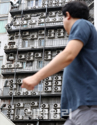 한 서울 시민이 에어컨 실외기로 가득찬 남대문로 건물 앞을 지나가고 있다. (사진=방인권 기자)