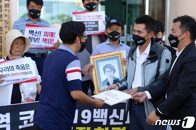 제주지역 코로나19 백신 피해자 가족들이 30일 제주도지사직 인수위원회 사무실이 있는 제주농어업인회관 앞에서 피해 대책 마련 촉구 기자회견을 가진 뒤 인수위원회 관계자에게 서한을 전달하고 있다.2022.6.30/뉴스1 © News1 홍수영 기자