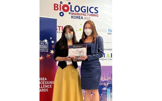 마켄의 세렌 옹(Serene Ong, 사진 오른쪽) 글로벌 세일즈 부사장이 주관사인 이마팩(IMAPAC) 관계자(사진 왼쪽)로부터 대한민국 바이오프로세싱 엑설런스 어워드 2022(Korea Bioprocessing Excellence Awards 2022)를 29일에 수상하고 기념 촬영을 하고 있다.
