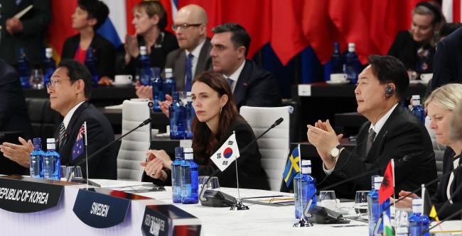 나토 정상회의 첫 참석 : 윤석열 대통령이 29일 스페인 마드리드 전시컨벤션센터(IFEMA)에서 열린 나토 동맹국-파트너국 정상회의에 참석해 기시다 후미오(왼쪽) 일본 총리, 저신다 아던(〃 두 번째) 뉴질랜드 총리, 마그달레나 안데르손(오른쪽) 스웨덴 총리와 나란히 앉아 박수를 치고 있다. 연합뉴스